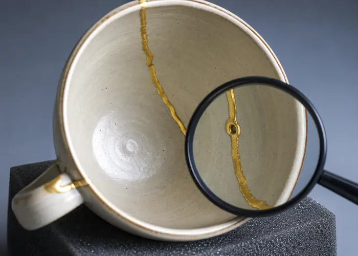 Emenda interna de uma caneca reparada sendo examinada sob luz lateral