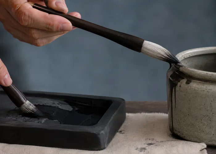 Pincel de sumi-ê com quantidade equilibrada de água e nanquim para traços finos