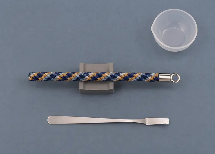 Terminal metálico colado e alinhado com o eixo da pulseira de kumihimo