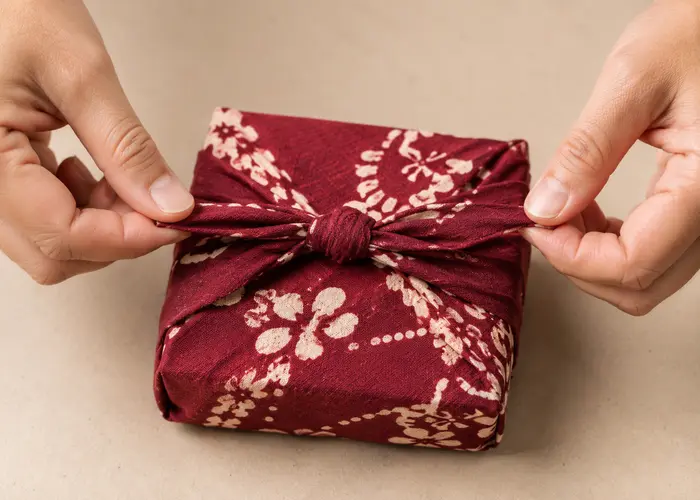 Nó quadrado baixo feito com furoshiki de algodão grosso sobre caixa pequena